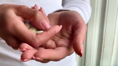 Kadın elini Vakumlu ambalaj hapları al. El pour tablet beyaz, yakın çekim. İlaç doz hap elinde. Homeopatik ilaç ek