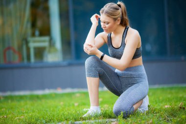 Dirsek yaralanma. Fitness kadın onun dirseğini acı ile