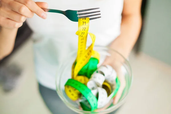 Concepto de dieta y salud. Mujer manos sosteniendo tazón con cinta métrica — Foto de Stock