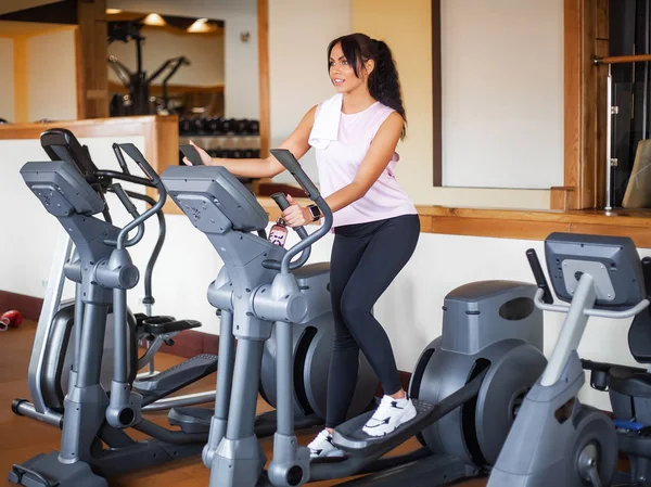 Young fitness woman working out in the gym. Woman working out on exercise bike