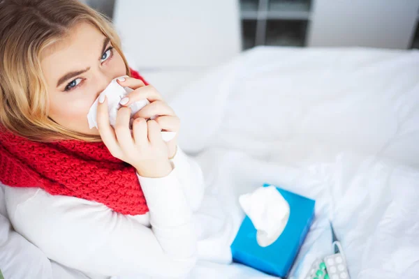 Wanita dengan virus flu terbaring di tempat tidur, dia mengukur suhu tubuhnya dengan termometer — Stok Foto