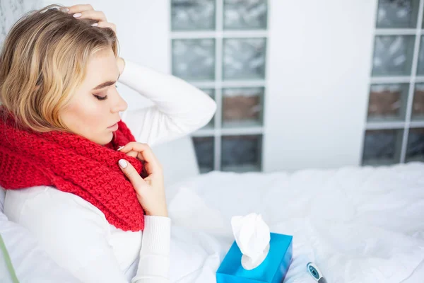 Mujer con el virus de la gripe acostada en la cama, que está midiendo su temperatura con un termómetro — Foto de Stock