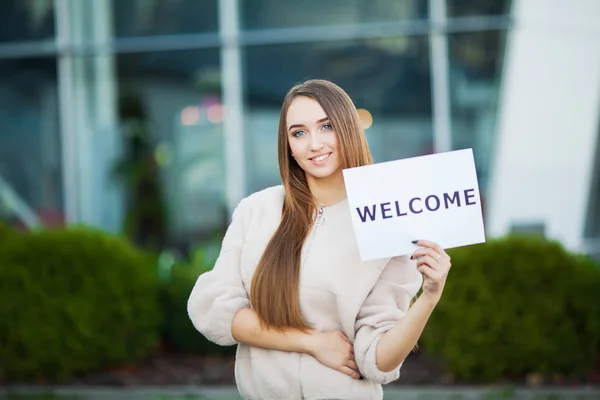 Women business with the poster with welcome message