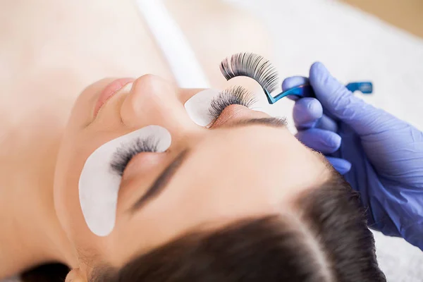 엘러 쉬 엑스 테. 가짜 Eyelashes. Eyelash Extension Procedure. 직업적 인 스타일리스트가 여성의 띠를 길게 늘인다. 미용실의 주인이자 고객 — 스톡 사진