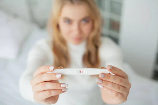 Chica mirando la prueba de embarazo. Mujer triste esperando los resultados de la prueba de embarazo — Foto de Stock