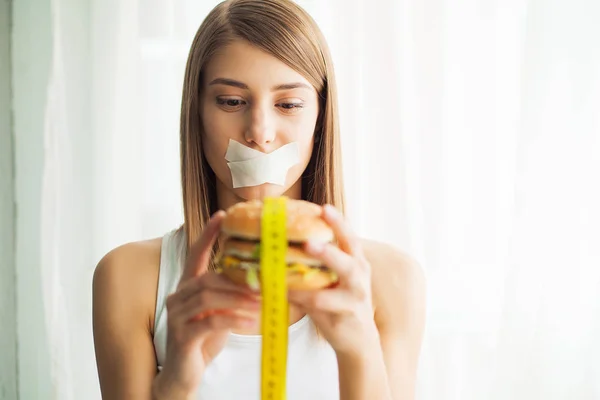 Дієта. Молода жінка зі стрічкою через рот, запобігає їй їсти шкідливу їжу. Концепція здорового харчування . — стокове фото