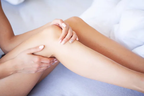 Jambes levées sur les bagages, jeune femme allongée au lit. La chambre blanche . — Photo