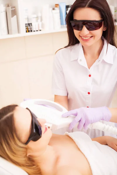 Lichaamsverzorging. Close-up van de schoonheidsspecialiste geven Laser epileren behandeling aan jonge vrouw gezicht — Stockfoto