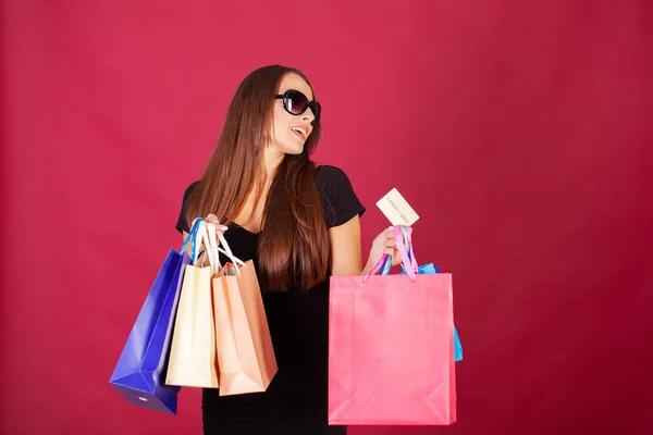 Compras. Mulher muito jovem elegantemente vestida de preto com sacos depois de fazer compras — Fotografia de Stock