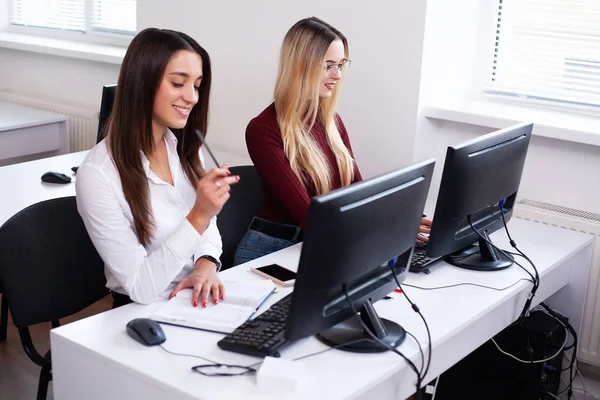 Duas colegas a trabalhar juntas. Duas colegas no escritório trabalhando juntas — Fotografia de Stock