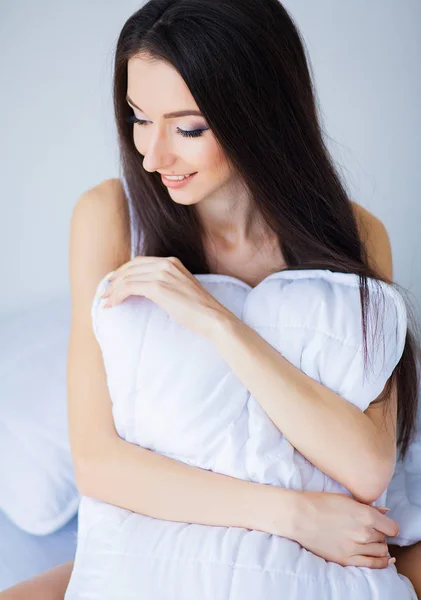 Bonne matinée. Portrait d'une jolie jeune femme brune souriante se relaxant dans un lit blanc — Photo