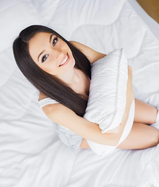 행복 한 아침입니다. 흰색 침대에서 편안 하 게 웃는 예쁜 젊은 갈색 머리 여자의 초상화 — 스톡 사진