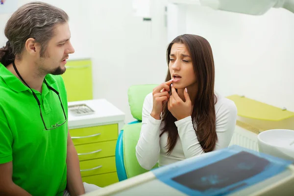 Οδοντίατρος στο οδοντιατρικό γραφείο μιλάει με γυναίκα ασθενή και προετοιμασία για τη θεραπεία — Φωτογραφία Αρχείου
