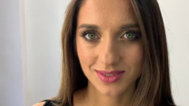 Güzellik Salonu. Sandalyede oturan genç güzel kız modeli. Makyaj sanatçısı makyaj kız yapar