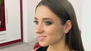 Güzellik Salonu. Sandalyede oturan genç güzel kız modeli. Makyaj sanatçısı makyaj kız yapar