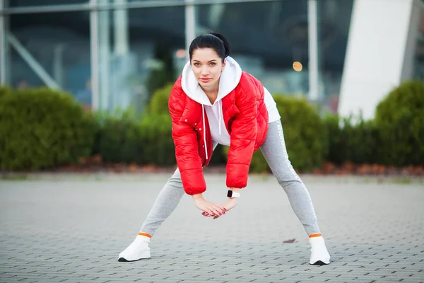 Chica de fitness. Mujer deportiva joven que se extiende en la ciudad moderna. Un estilo de vida saludable en la gran ciudad —  Fotos de Stock