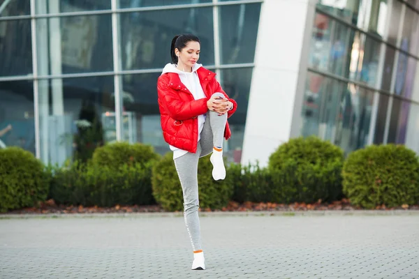 Fitness meisje. Jonge sportvrouw die zich uitstrekt in de moderne stad. Gezonde levensstijl in de grote stad — Stockfoto