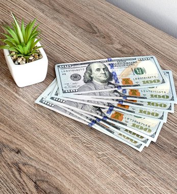 Tahta masadaki 100 dolarlık banknotlar.