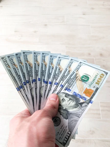 Hand holding banknote bundle of US dollar in hand — Stock Photo, Image