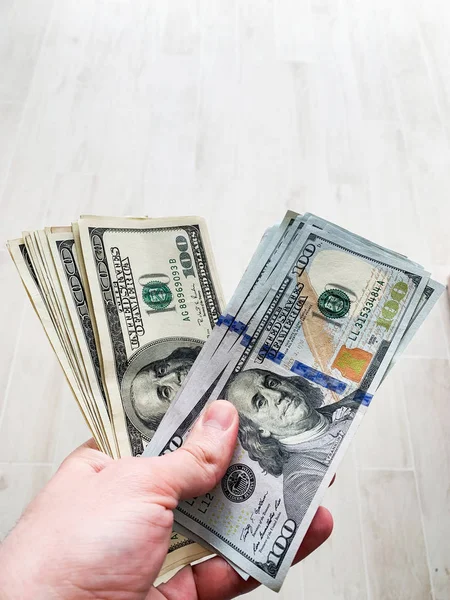 Hand holding banknote bundle of US dollar in hand