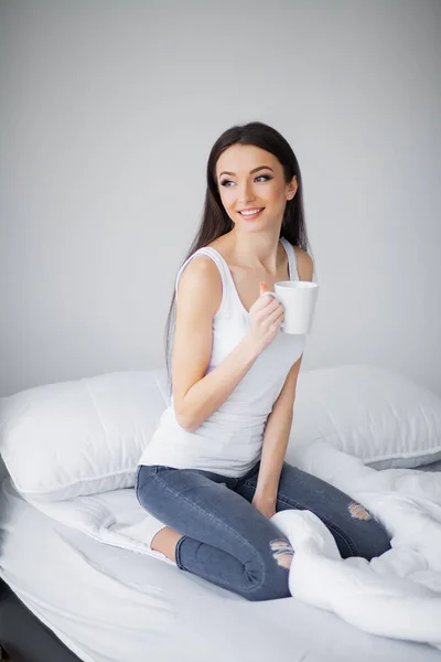 Ontspannen op bed tijdens het weekend. Mooie vrouw ontspannen op een bed en op zoek gelukkig — Stockfoto