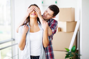 Genç mutlu çift yeni evlerine taşınıyor. Bavulları açıp yeni evi temizliyorlar.