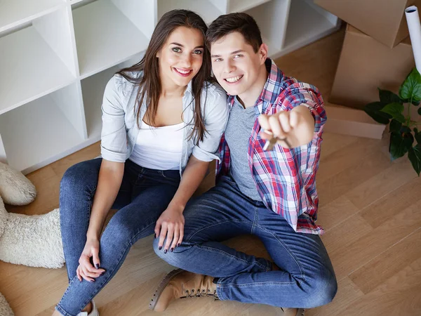 Joven pareja feliz mudarse a su nuevo hogar. Desempaquetan y limpian nuevo hogar — Foto de Stock