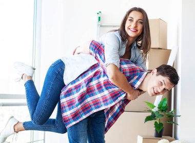 Genç mutlu çift yeni evlerine taşınıyor. Bavulları açıp yeni evi temizliyorlar.