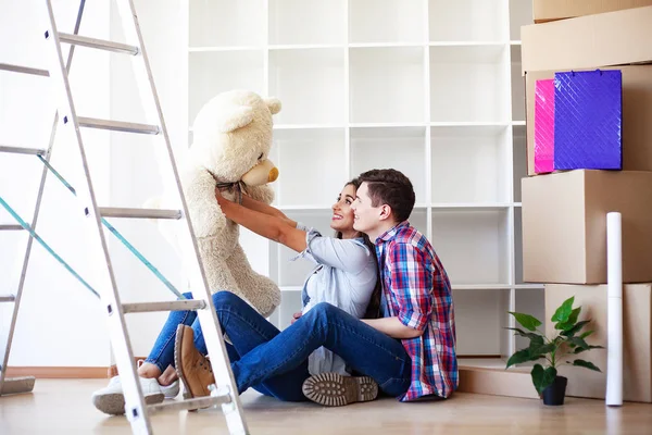 Unga lyckliga par flyttar in i sitt nya hem. De packar upp och städar upp nytt hem — Stockfoto