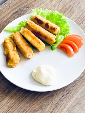 Kızarmış mozzarella peyniri beyaz tabakta ekmekli çubuklar