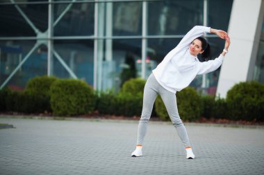 Fitness kadının Stadyumu arka plan ayakta egzersiz yapması
