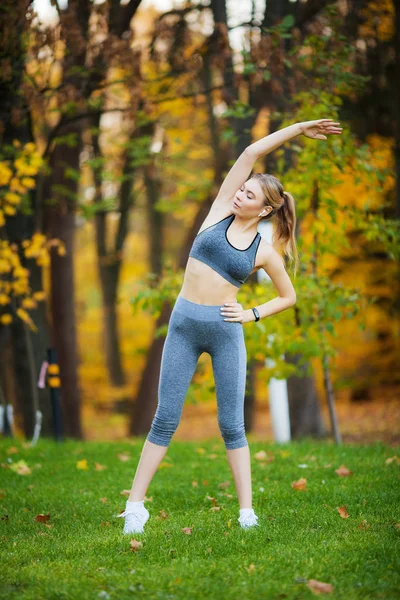 Fitness. Kobieta robi ćwiczenia rozciągające na park — Zdjęcie stockowe