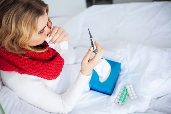 Fiebre y frío. Retrato de la hermosa mujer contrajo la gripe, teniendo dolor de cabeza y alta temperatura. Primer plano de niña enferma cubierta en manta, sintiéndose mal sosteniendo termómetro. Salud. Alta resolución — Foto de Stock