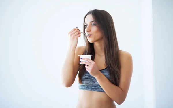 Dieta. Jovem feliz comendo iogurte na cozinha — Fotografia de Stock