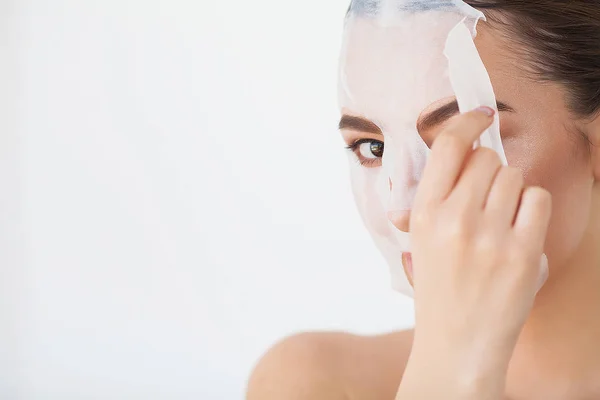 Cuidado com a pele. Jovem fêmea removendo máscara da pele facial. Mulher beleza rosto — Fotografia de Stock
