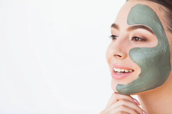 Mascarilla facial. Hermosa mujer sonriente aplicando máscara en la cara — Foto de Stock