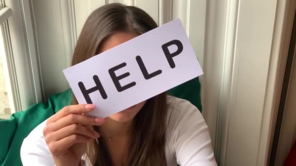 Woman need help. Sad woman holding help sign — Stock Video