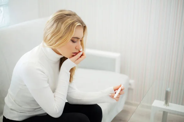 Test di gravidanza positivo. Ritratto di giovane donna disperata che tiene il bastone del test di gravidanza — Foto Stock