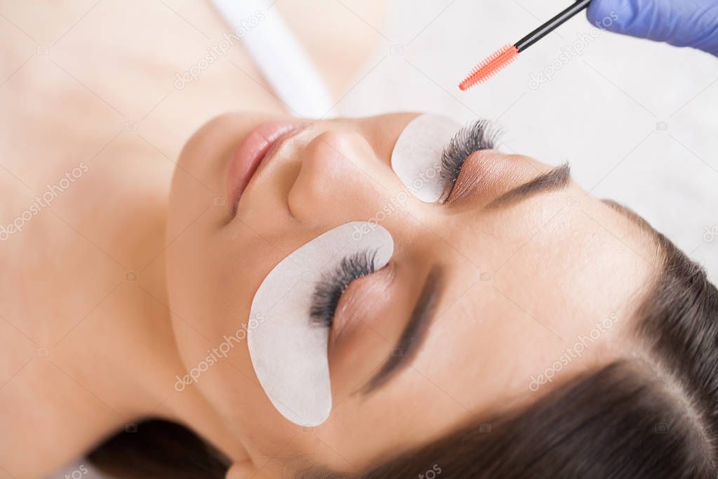 Eyelashes extensions. Fake Eyelashes. Eyelash Extension Procedure. Professional stylist lengthening female lashes. Master and a client in a beauty salon