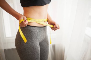Eller bel bandı ile ölçme. İnce ve sağlıklı kadın evinde