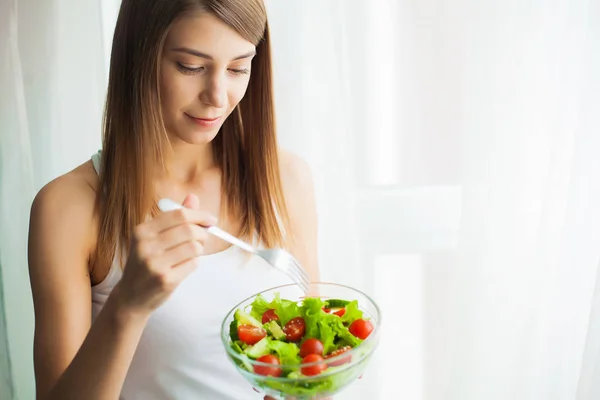 Дієта. Молода жінка їсть салат і тримає змішаний салат — стокове фото