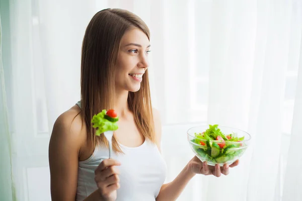 Kost. Ung kvinna äter sallad och håller en blandad sallad — Stockfoto