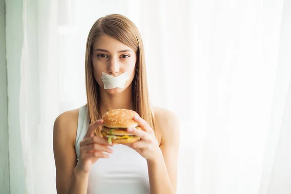 Kost. Ung kvinna hindrar henne att äta skräpmat. Hälsosam kost koncept — Stockfoto