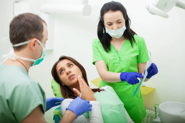 Paciente em odontologia. Mulher bonita visitando seu dentista na clínica — Fotografia de Stock