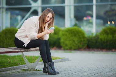 Bir bankta bir şehir parkında oturan depresif kadın