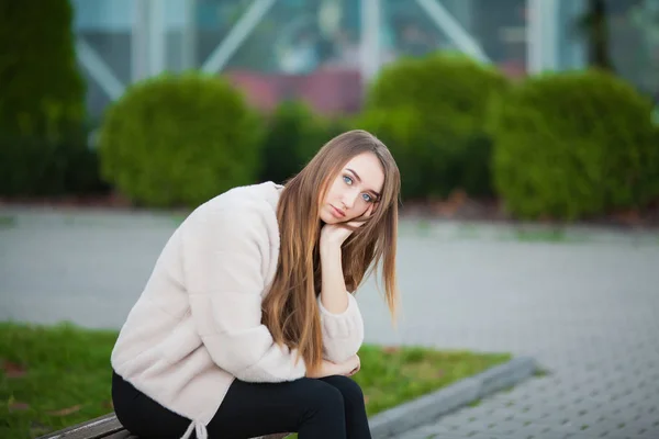 Mulher deprimida sentada em um parque da cidade em um banco — Fotografia de Stock