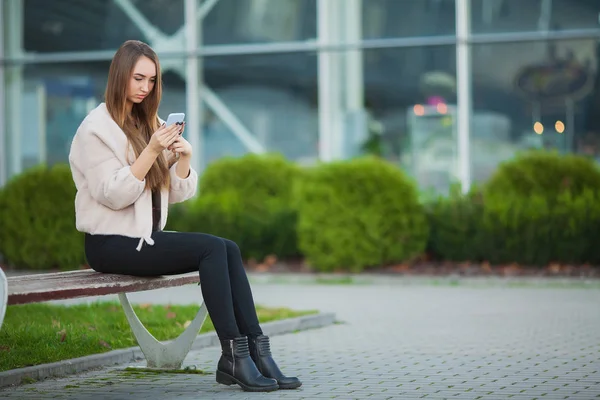 Mujer deprimida sentada en un parque de la ciudad en un banco — Foto de Stock