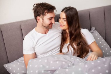 Mutlu çift yatakta eğlenmek. Birbirlerine zevk yatak odasında samimi şehvetli genç çift