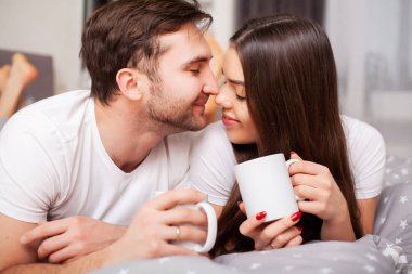 Mutlu çift yatakta eğlenmek. Birbirlerine zevk yatak odasında samimi şehvetli genç çift