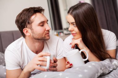 Mutlu çift yatakta eğlenmek. Birbirlerine zevk yatak odasında samimi şehvetli genç çift